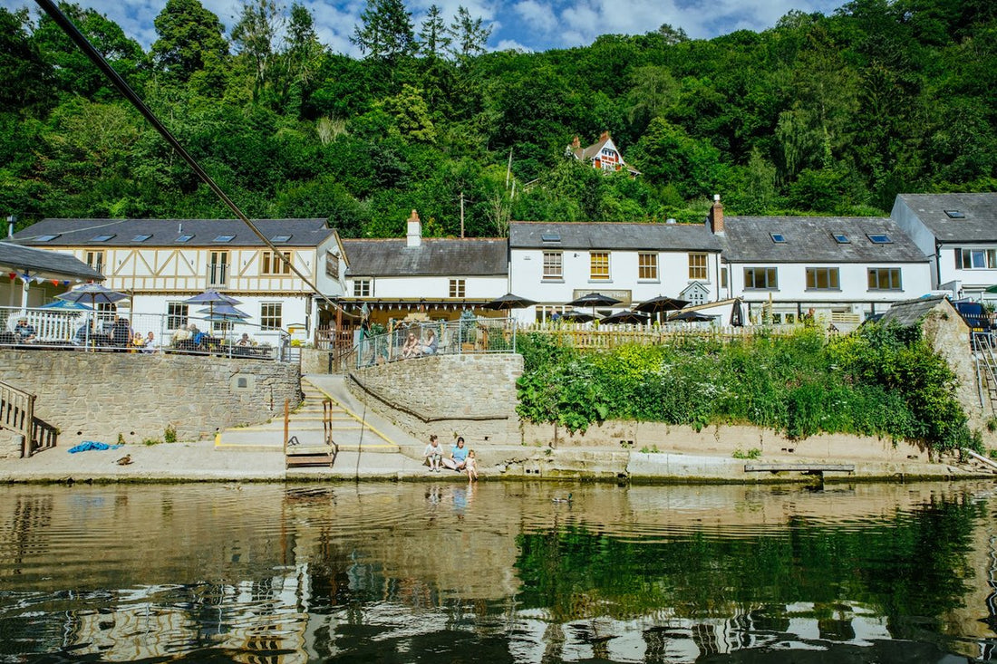 The Saracens Head Inn seen from the River Wye at Symonds Yat East, with its riverside terrace and wooded hillside behind